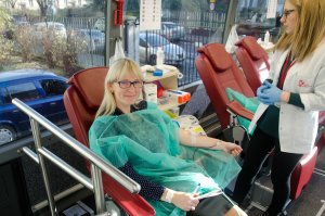 Kobieta oddaje krew, obok osoba z obsługi punktu poboru krwi