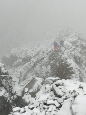 Zaśnieżony szczyt w tle dwóch mężczyzn we mgle pokonuje szlak
