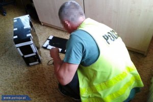 policjant przy zabezpieczaniu sprzętu komputerowego