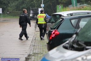 samochody na parkingu i idący niemieccy policjanci