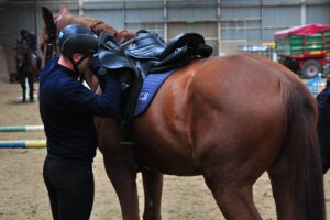 Szkolenie Zespołów Konnych Policji, policjant stoi przy koniu