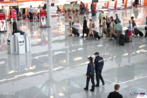 policjanci patrolują halę odlotów na lotnisku