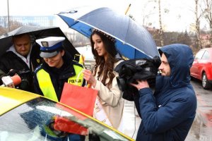 Miss Polski i policjantka oraz dziennikarze przy zatrzymanym samochodzie