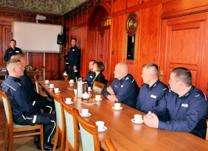 grupa policjantów siedzi przy stole