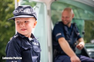 Uśmiechnięte dziecko w mundurze policjanta.