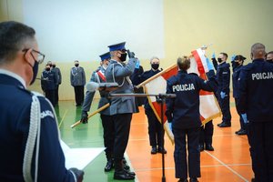 Sala gimnastyczna Oddziału Prewencji Policji w Łodzi, uroczystość ślubowania, policjanci składają ślubowanie na sztandar komendy policji.