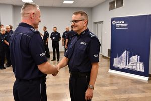 policjant gratuluje nowemu komendantowi objęcia stanowiska