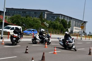 Trzech policjantów na motocyklach pokonuje ósemkę.