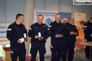 nagrodzeni za marszobieg policjanci stoją w szeregu prezentując nagrody