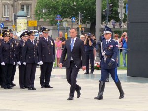 Prezydent Andrzej Duda w asyście Komendanta Głównego Policji dokonuje przeglądu pododdziałów, w tle goście: przedstawiciele policji z innych krajów