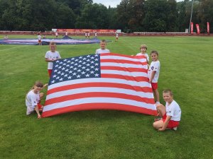 dzieci na murawie prezentują flagę USA