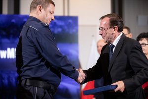 minister Mariusz Kamiński wręcza nagrodę policjantowi