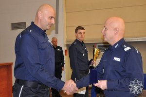 Komendant Główny Policji gratuluje policjantowi i wręcza mu nagrodę