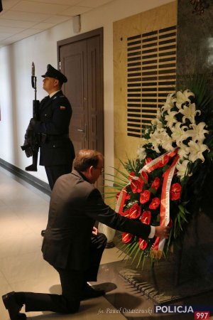 Minister Spraw Wewnętrznych i Administracji i składa wieniec kwiatów pod tablicą upamiętniającą poległych policjantów