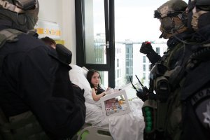 Policyjni kontrterroryści odwiedzający dzieci w szpitalnych salach.