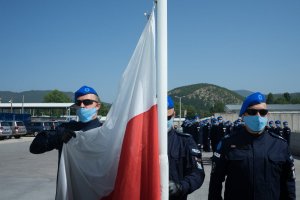 Policjanci JSPP w Kosowie obok masztu z flagą Polski