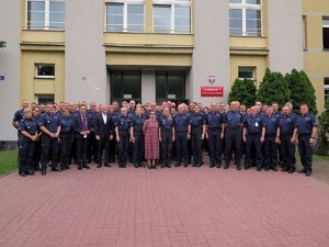 Zdjęcie grupowe uczestników konferencji na tle budynku Centrum Szkolenia Policji w Legionowie