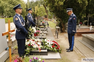 dwaj policjanci na warcie honorowej przy grobie generała Papały, naprzeciwko nich stoi nadinspektor Roman Kuster oddając hołd