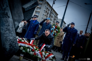 Uczestnicy uroczystości składają wieńce pod pomnikiem.