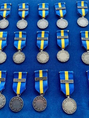 Medale leżą na niebieskim tle.