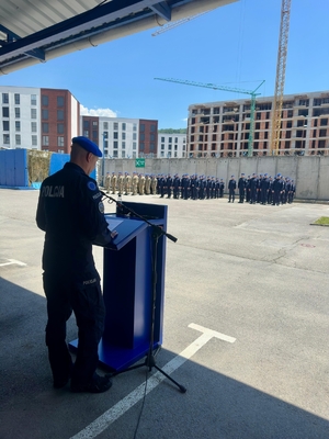 Funkcjonariusz XXXVIII rotacji JSPP w Kosowie podczas uroczystości stoi przy mównicy.