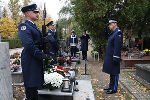 komendant składa wieniec na grobie.