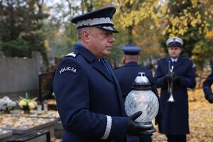 komendant składa wieniec na grobie.