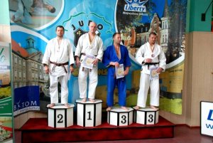 czterej zawodnicy stojący z dyplomami na podium zawodów judo