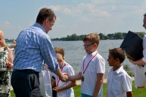 minister Mariusz Błaszczak gratuluje dzieciom i wręcza im prezenty