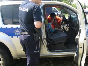 policjant pokazuje dzieciom wnętrze radiowozu policyjnego