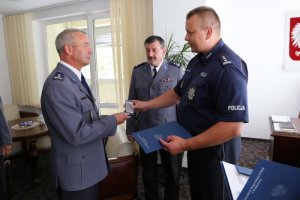 Komendant Wojewódzki Policji w Bydgoszczy insp. Paweł Spychała wręcza medal policjantowi