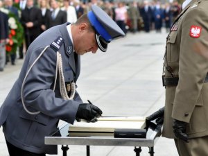 uroczystości ku czci poległych i walczących o Warszawę w 1944 roku, komendant stołeczny policji insp. Robert Żebrowski wpisuje się do księgi pamiątkowej przy Grobie Nieznanego Żołniera
