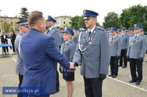 policjanci w rzędach jednemu z nich gratuluje minister Jarosław Zieliński