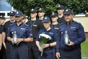 wykładowcy oraz słuchacze Szkoły Policji w Katowicach ze zniczami oraz kwiatami w rękach