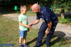policjant gratuluje małemu chłopcu