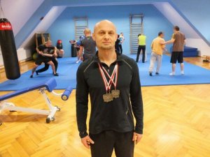 Asp. sztab. Waldemar Czaicki z medalami na sali treningowej