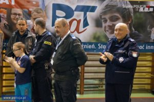 II Przystanek PaT w Chorzowie, trzej policjanci stoją w tle baner programu PaT