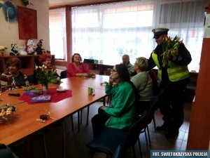 policjant rozdaje kwiaty kobietom