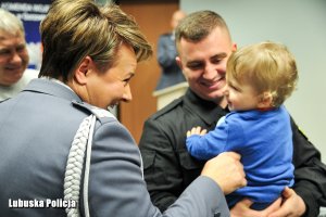 Komendant Wojewódzki Policji w Gorzowie Wielkopolskim nadinspektor Helena Michalak z policjantem oraz jego dzieckiem na ręku