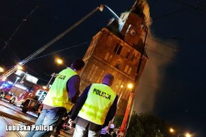 policjanci obserwują akcję gaśniczą katedry