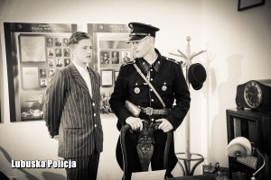 Policjant w historycznym mundurze Policji Państwowej wraz z mężczyzną