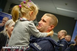 policjant z córką na rękach