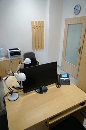 zdjęcie pokoju, w którym znajdują się meble, monitor, krzesła oraz drukarka