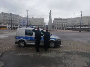 Dwaj policjanci i radiowóz, w tle pomnik Kościuszki.