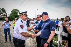 komendant straży miejskiej wręcza statuetkę z cy komendanta wojewódzkiego policji w Łodzi , obaj w mundurach