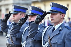 trzej policjanci z pocztu flagowego oddają honor