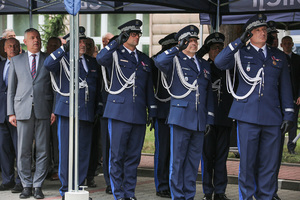 Zastępca komendanta głównego Policji wraz z komendantem CBŚP i innymi funkcjonariuszami oddaje honor.