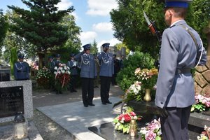 Fotografia kolorowa na której widać dwóch policjantów oddających honor zmarłemu gen. Markowi Papale w 21. rocznicę jego śmierci.