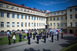 Zdjęcie kolorowe. Policjanci i policyjni muzycy występujący przed szpitalem