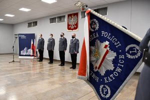 Na pierwszym planie sztandar Komendy Wojewódzkiej Policji w Katowicach, w tle kierownictwo śląskiej Policji.